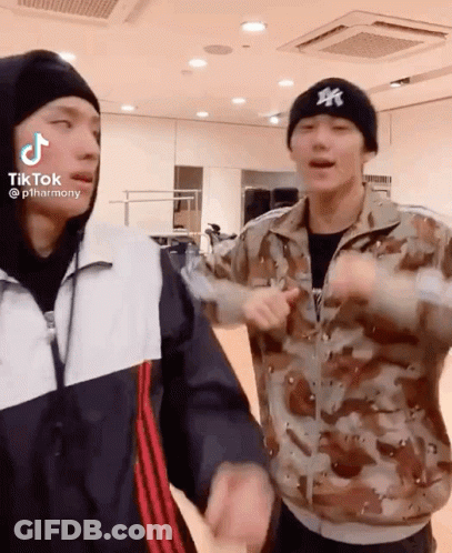 Two Men Are Standing Next To Each Other In A Room . One Of The Men Is Wearing A Ny Hat . GIF