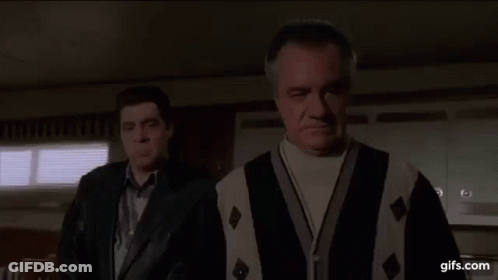 Two Men Are Standing Next To Each Other In A Room . One Of The Men Is Wearing A Sweater And A Leather Jacket . GIF