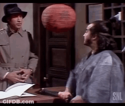 Two Men Are Standing Next To Each Other In A Room Talking To Each Other . GIF