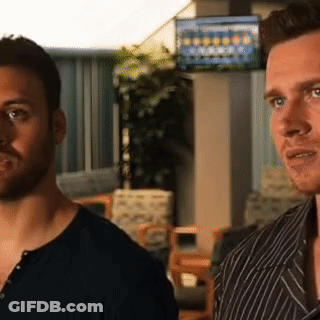Two Men Are Standing Next To Each Other In A Room With A Tv On The Wall GIF