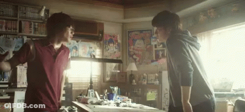 Two Men Are Standing Next To Each Other In A Room With Posters On The Wall . GIF