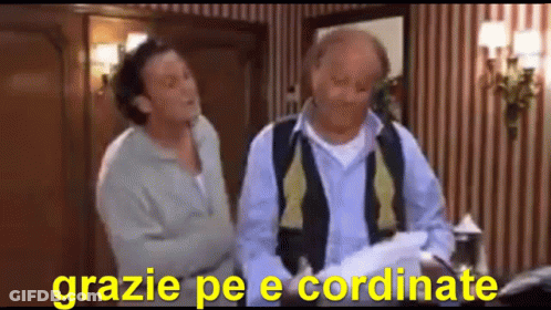Two Men Are Standing Next To Each Other In A Room With The Words Grazie Pe E Coordinate In The Corner GIF