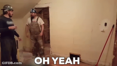 Two Men Are Standing Next To Each Other In A Room With The Words `` Oh Yeah '' On The Wall . GIF