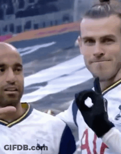 Two Men Are Standing Next To Each Other In A Stadium And One Of Them Is Wearing A Black Glove . GIF
