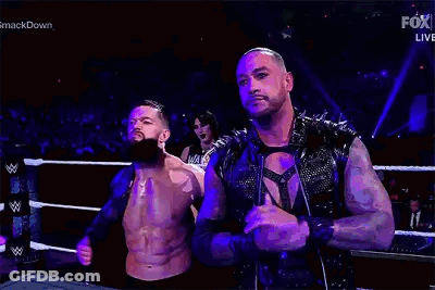 Two Men Are Standing Next To Each Other In A Wrestling Ring . One Of The Men Has A Beard . GIF