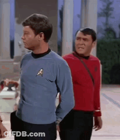 Two Men Are Standing Next To Each Other In Front Of A Building . GIF