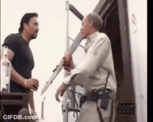 Two Men Are Standing Next To Each Other In Front Of A Building . GIF