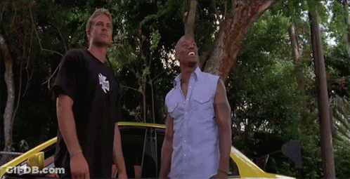 Two Men Are Standing Next To Each Other In Front Of A Car GIF