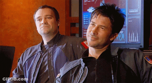 Two Men Standing In Front Of Computer Monitor GIF