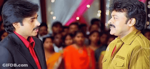 Two Men Are Standing Next To Each Other In Front Of A Crowd And Talking To Each Other . GIF