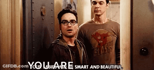 Two Men Are Standing Next To Each Other In Front Of A Door . One Of The Men Is Wearing A Flash Shirt . GIF