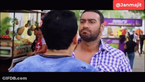 Two Men Are Standing Next To Each Other In Front Of A Fruit Stand And A Sign That Says Janmajit GIF