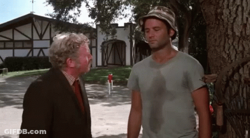 Two Men Are Standing Next To Each Other In Front Of A House And Talking GIF