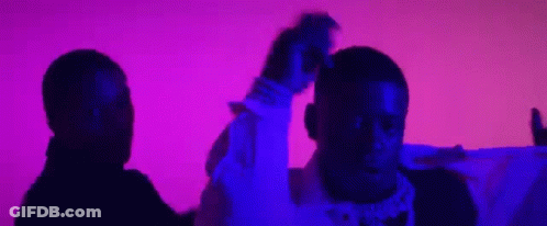 Two Men Are Standing Next To Each Other In Front Of A Purple And Pink Background . GIF