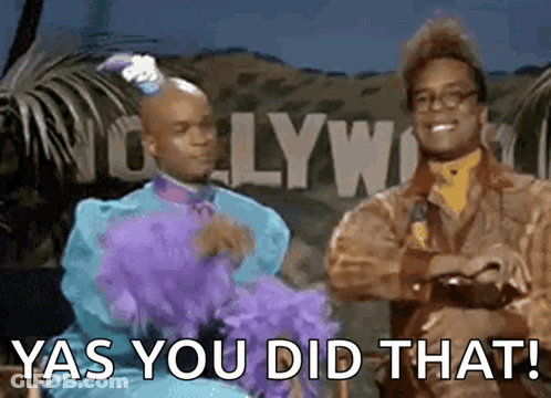 Two Men Are Standing Next To Each Other In Front Of A Sign That Says Yas You Did That GIF