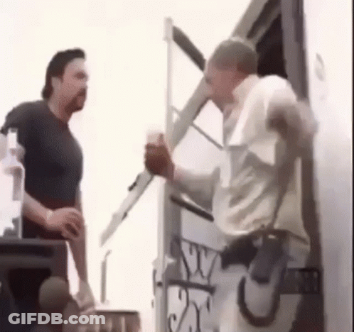 Two Men Are Standing Next To Each Other In Front Of A Trailer . GIF