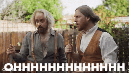 Two Men Standing By Wooden Fence GIF