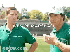Two Men Are Standing Next To Each Other On A Field With The Words `` We Are Marshall '' Written On The Bottom . GIF