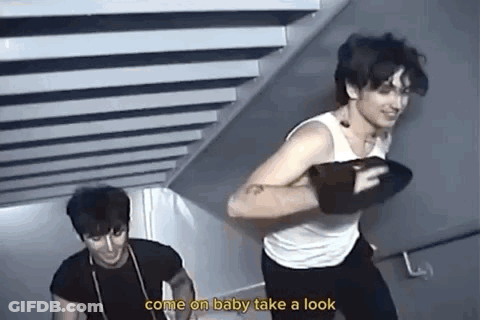 Two Men Are Standing Next To Each Other On A Set Of Stairs And One Of Them Is Holding A Boxing Glove . GIF