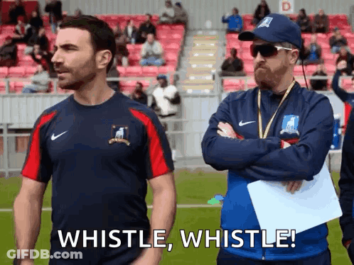 Two Men Are Standing Next To Each Other On A Soccer Field . GIF