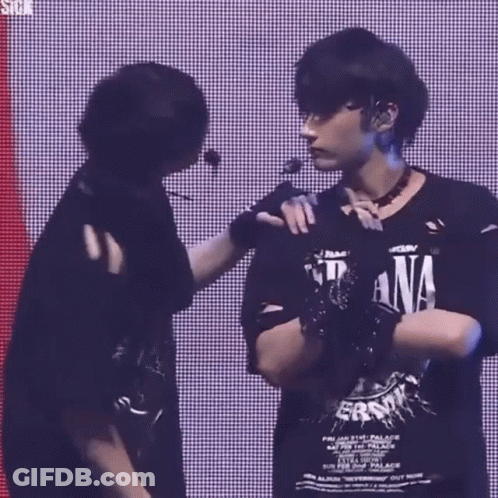 Two Men Are Standing Next To Each Other On A Stage . GIF