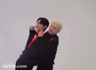 Two Men Are Standing Next To Each Other On A White Background And Holding Hands . GIF
