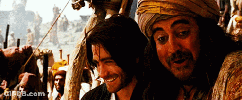 Two Men Are Standing Next To Each Other Smiling And Looking At The Camera GIF
