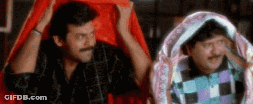 Two Men Are Standing Next To Each Other Under A Red Cloth . GIF