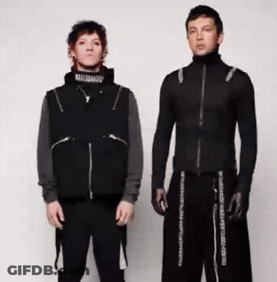 Two Men Are Standing Next To Each Other Wearing Black Clothes And Gloves . GIF