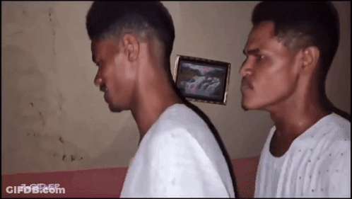 Two Men Are Standing Next To Each Other With A Picture Of A Car On The Wall Behind Them GIF