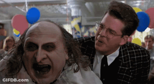 Two Men Are Standing Next To Each Other With Balloons Hanging From The Ceiling In The Background GIF
