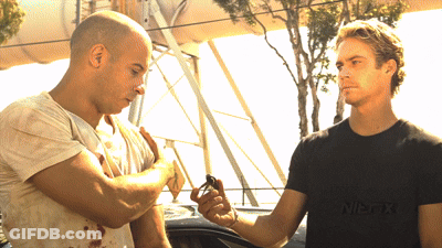 Two Men Are Standing Next To Each Other With One Wearing A Black Shirt That Says Wes-Fix GIF