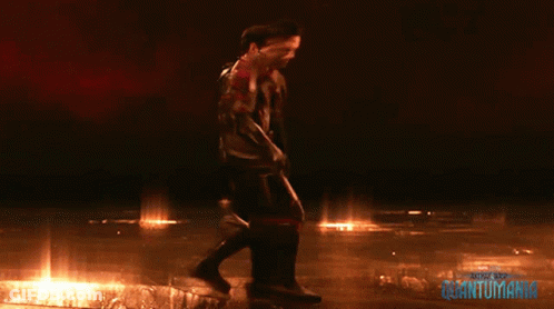 Two Men Standing Next To Quantumania Behind Them GIF