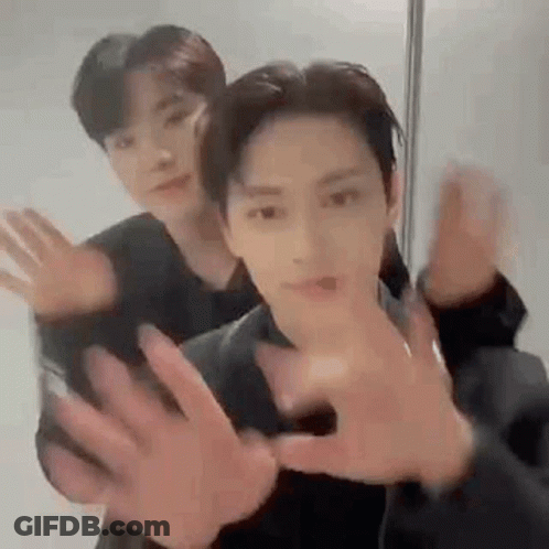 Two Men Are Standing Next To Each Other With Their Hands Outstretched . GIF