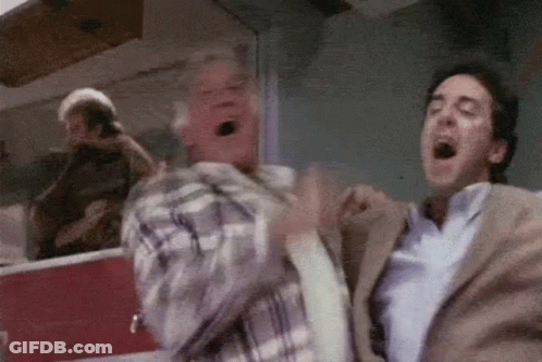 Two Men Are Standing Next To Each Other With Their Mouths Open In A Room . GIF