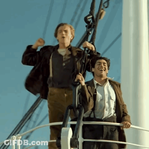 Two Men Are Standing On A Boat Laughing And Raising Their Arms In The Air GIF