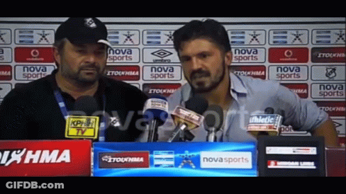 Two Men Are Talking In Front Of A Nova Sports Banner GIF