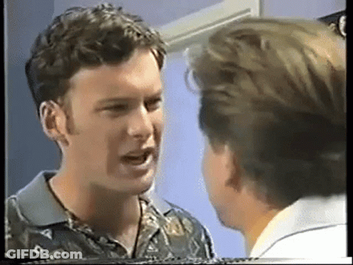Two Men Are Talking To Each Other In A Room GIF