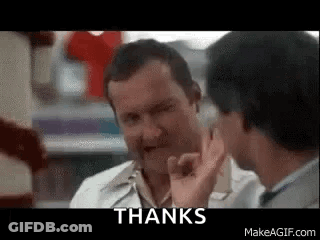 Two Men Are Talking To Each Other In A Store And One Of Them Is Giving A Thumbs Up Sign . GIF