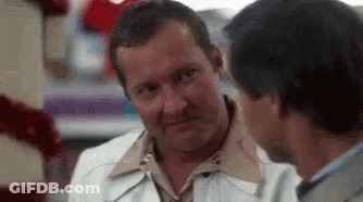 Two Men Are Talking To Each Other In A Store And One Of Them Is Making A Funny Face . GIF