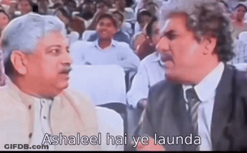 Two Men Are Talking To Each Other In Front Of A Crowd Of People . GIF