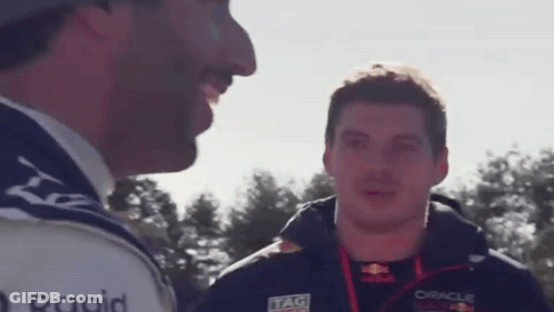 Two Men Are Talking To Each Other In Front Of Trees . GIF