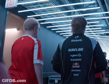 Two Men Are Walking Down A Hallway And One Of Them Is Wearing An Aleksib Navi.gg Jacket GIF