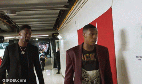 Two Men Are Walking Down A Hallway With A Sign That Says Bulls Staff Only On It GIF