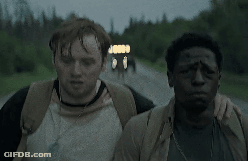 Two Men Are Walking Down A Road And One Has A Bandage On His Forehead GIF