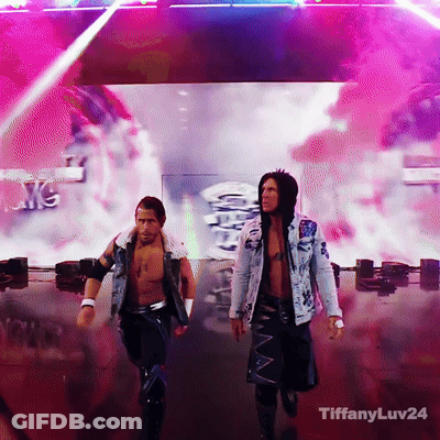 Two Men Are Walking On A Stage With Tiffanyluv24 On The Bottom Right GIF
