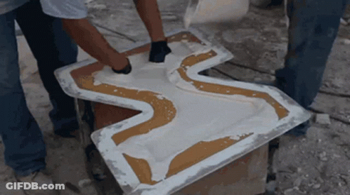 Two Men Are Working On A Piece Of Plastic That Looks Like A Cross GIF