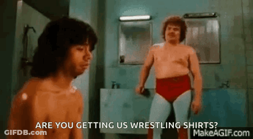 Two Men Are Wrestling In A Bathroom And One Of Them Is Asking If They Are Getting Us Wrestling Shirts . GIF