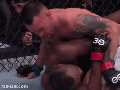 Two Men Are Wrestling In A Cage And One Of Them Has The Number 30 On His Gloves . GIF