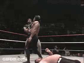 Two Men Are Wrestling In A Ring And One Is Laying On The Floor GIF